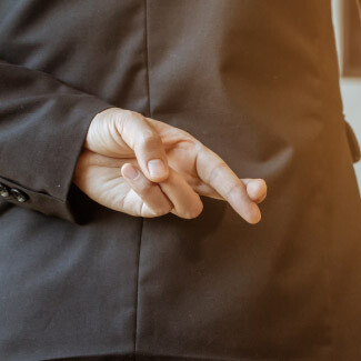 Male shaking hands with fingers crossed behind his back Icon